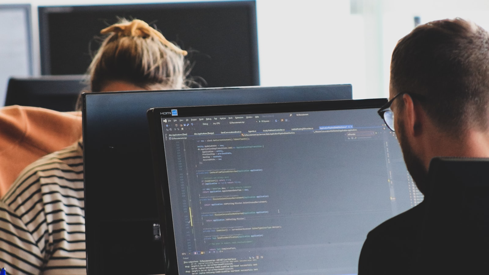 Woman in black shirt sitting beside black flat screen computer monitor — photo by Compagnons on Unsplash