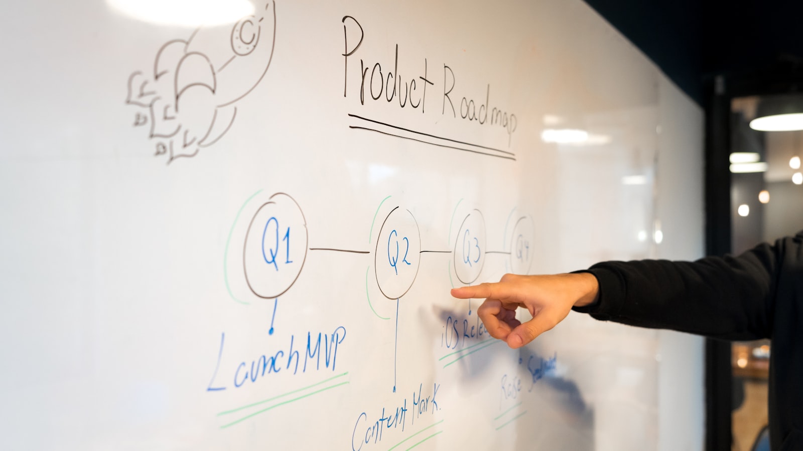 Person writing on white board — photo by Slidebean on Unsplash