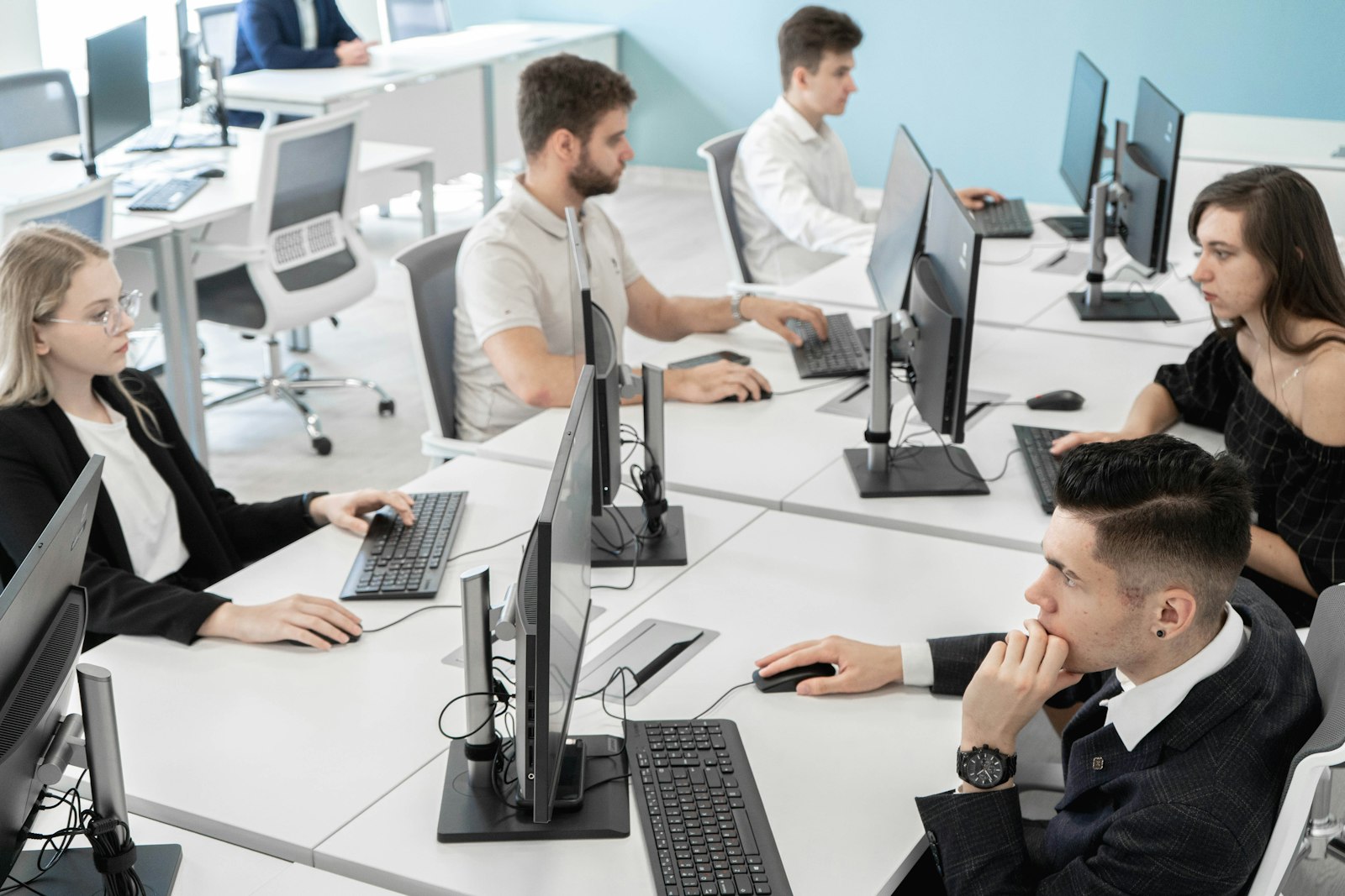 A group of people sitting at a table with computers — photo by RUT MIIT on Unsplash