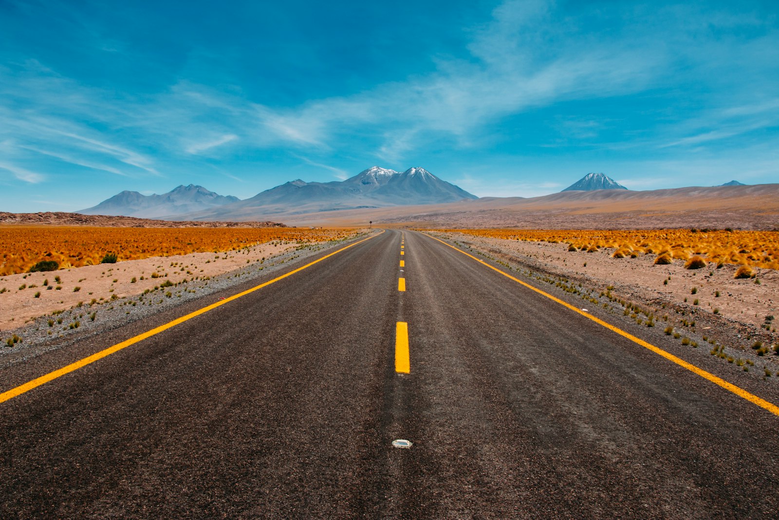 Lone road going to mountains — photo by Diego Jimenez on Unsplash