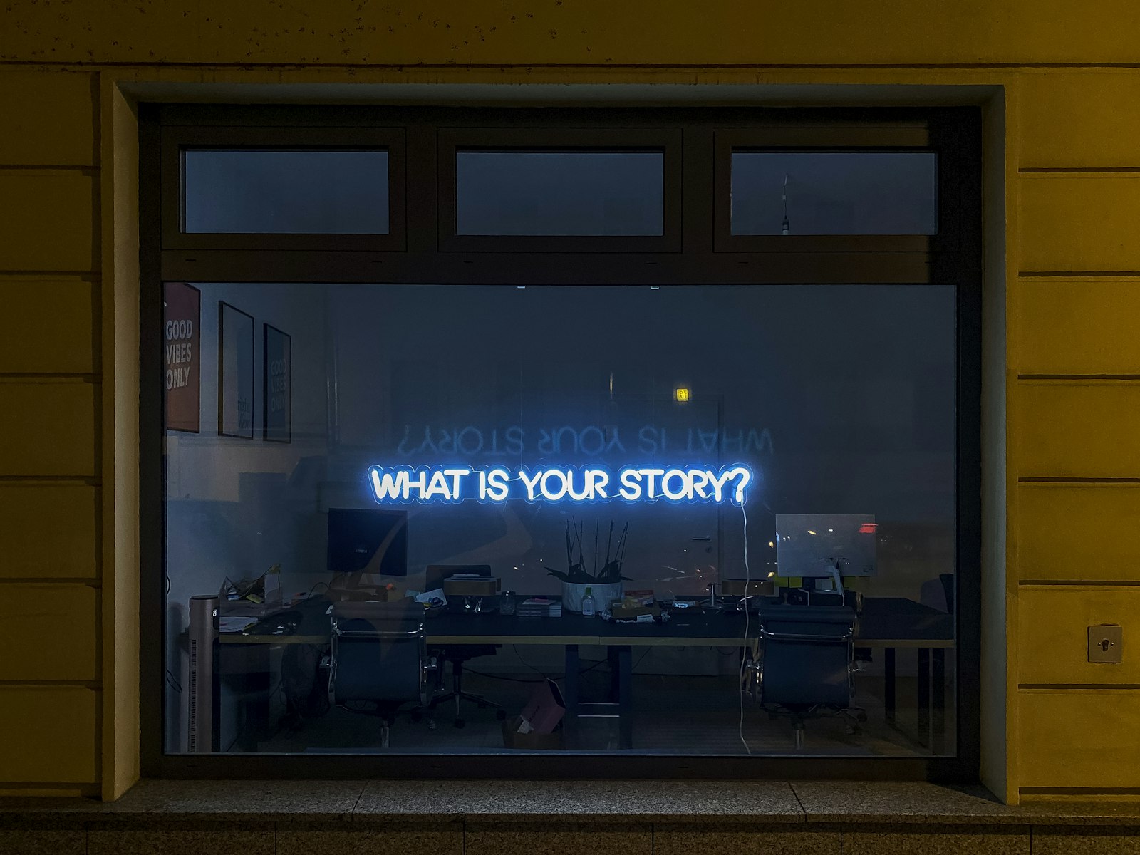 Neon sign in office window — photo by Etienne Girardet on Unsplash