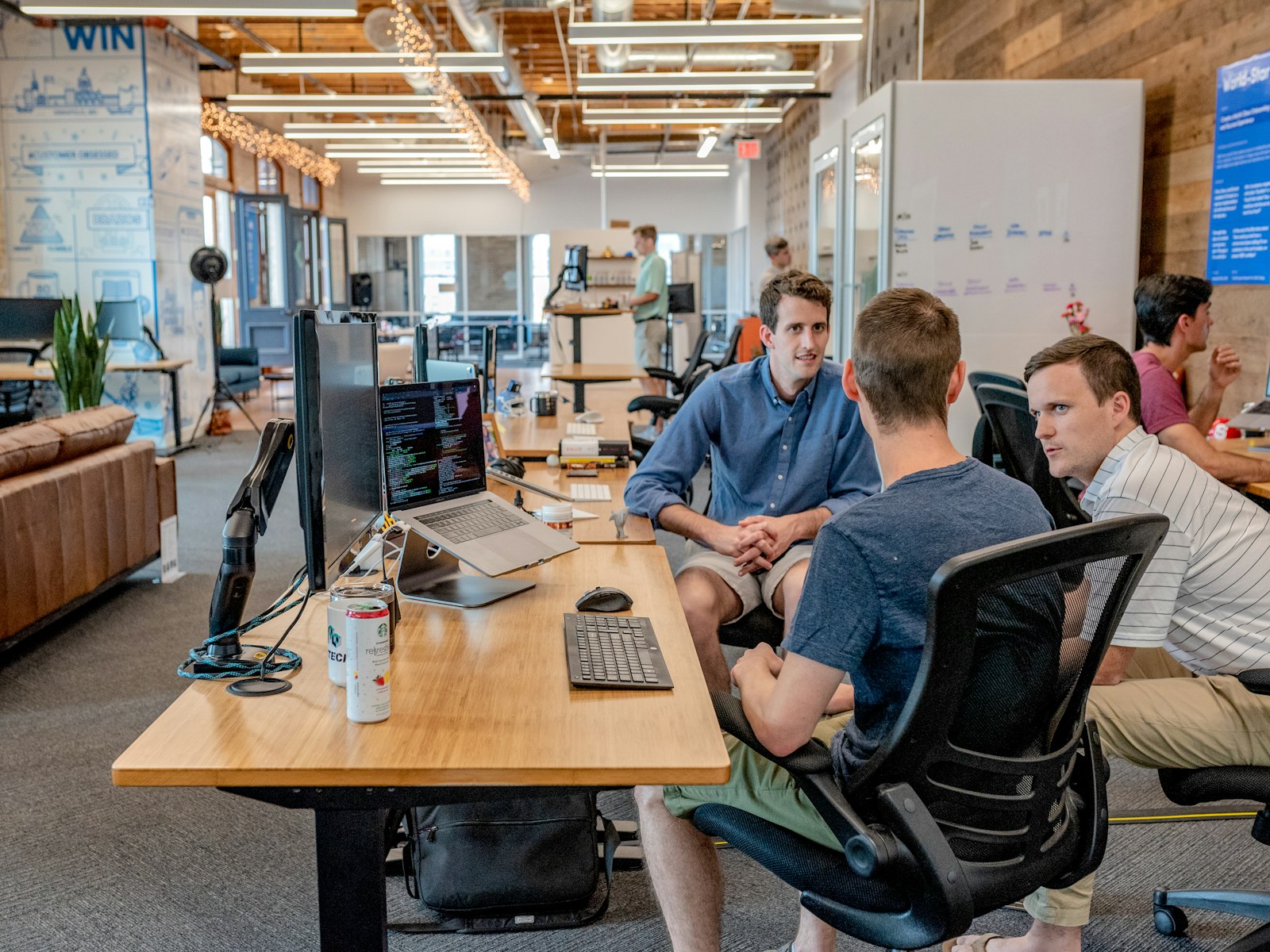 Three men sitting on chair beside tables — photo by Austin Distel on Unsplash
