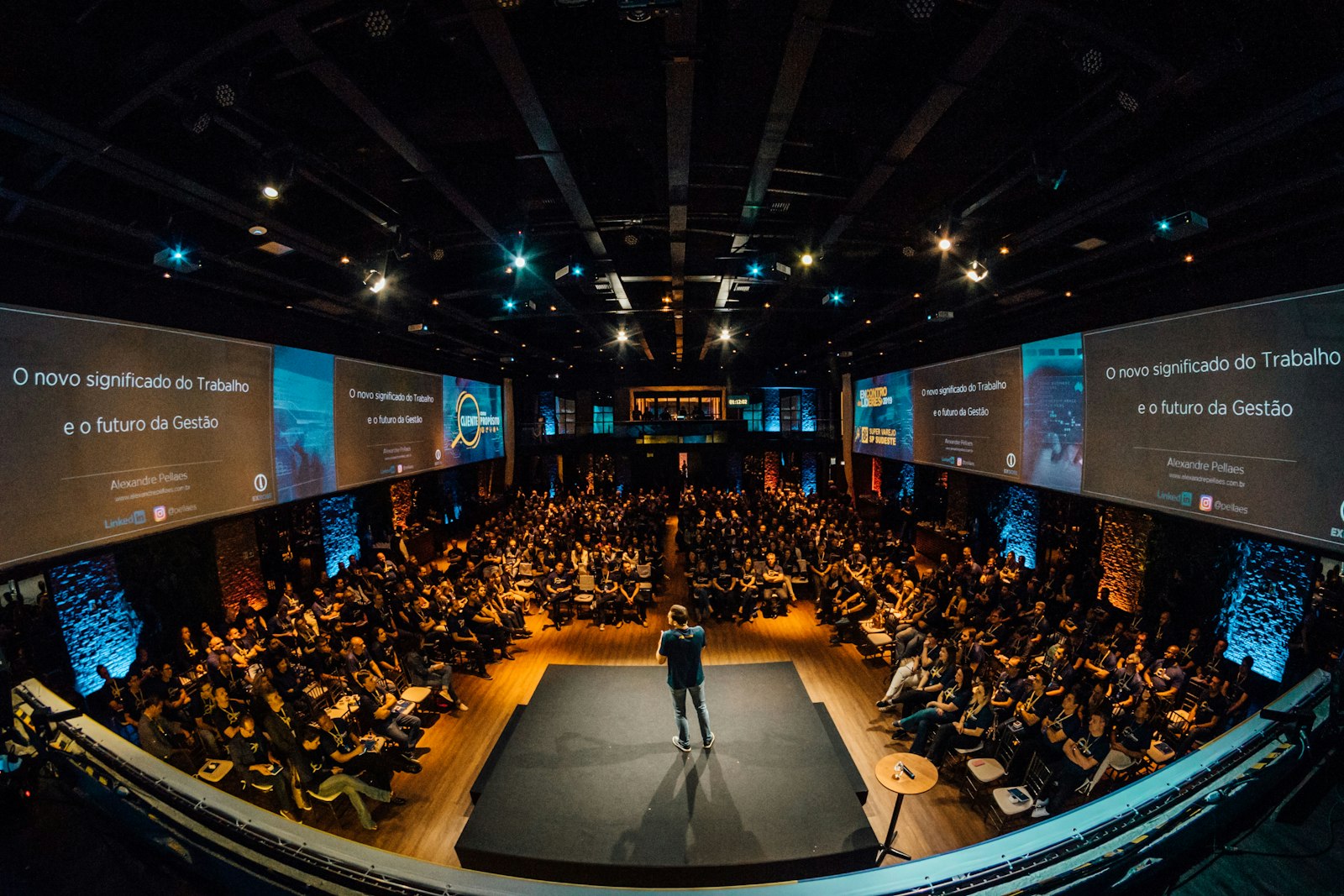 Keynote speaker on stage before a packed conference audience — photo by Alexandre Pellaes on Unsplash